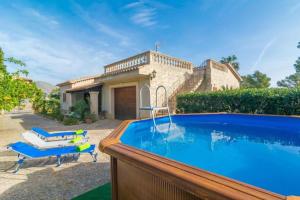 a swimming pool in front of a house at Villa Ginebro Puerto Pollença in Port de Pollensa