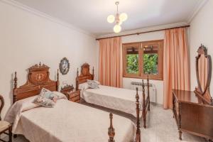 a bedroom with two beds and a desk and a window at Villa Ginebro Puerto Pollença in Port de Pollensa +21 photos