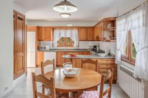 a kitchen with wooden cabinets and a wooden table at Villa Ginebro Puerto Pollença in Port de Pollensa