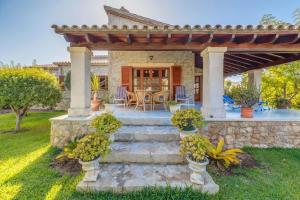 a stone house with a pergola and a patio at Villa Ginebro Puerto Pollença in Port de Pollensa