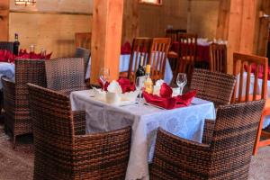 a table with wine glasses and red flowers on it at Innos Royale Suites in Rukungiri