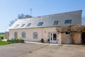 a white house with solar panels on the roof at Chambres D'hôtes De Kerantum in Mahalon