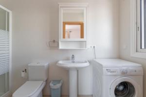 a white bathroom with a sink and a washing machine at Apartamento Corazón de Nerja in Nerja +12 photos