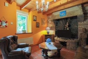 a living room with a tv and a stone fireplace at Gîte Ty Nevez in Lanvellec