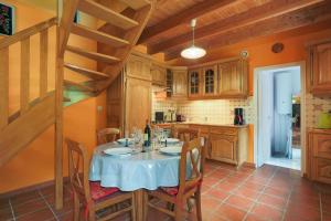 a kitchen with a table with chairs and a staircase at Gîte Ty Nevez in Lanvellec +21 photos