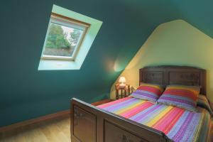 a bedroom with a wooden bed with a window at Gîte Ty Nevez in Lanvellec