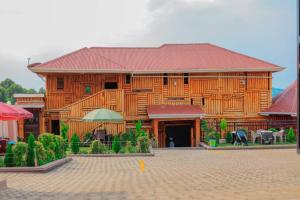 a large wooden building with a patio in front of it at Innos Royale Suites in Rukungiri