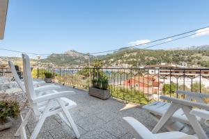 a balcony with white chairs and a view of the water at Can Joi 12 in Sóller