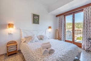 a bedroom with a large bed with two towels on it at Can Joi 12 in Sóller