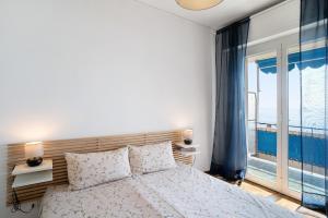 a bedroom with a bed and a large window at Margherita in Ospedaletti