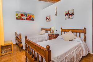 two beds in a bedroom with white walls at Villa Moreno in Pollença +12 photos