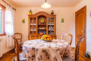 a dining room with a table with a bowl of fruit on it at Es Fasser in Son Servera