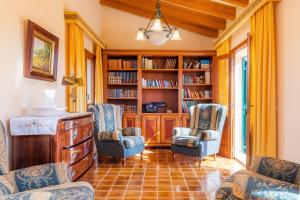 a living room with two chairs and a book shelf at Es Fasser in Son Servera