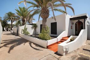 a house with a palm tree in front of it at Villa Mar in Teguise
