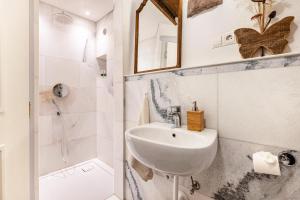 a white bathroom with a sink and a shower at Historisches Apartment Duregghof in San Genesio Atesino +29 photos