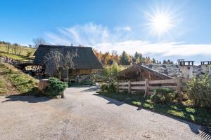 a dirt road leading to a barn with the sun in the sky at Historisches Apartment Duregghof in San Genesio Atesino