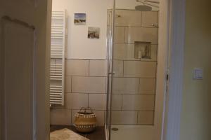 a shower with a glass door in a bathroom at Ferienwohnung Harz Idylle 2 in Güntersberge +29 photos