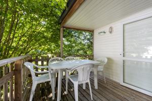 a white table and chairs on a deck at Mobilhome du Soleil in Saint-Pompont
