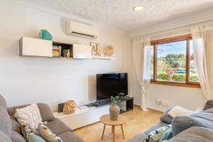a living room with a couch and a tv at Holytom Puerto Pollensa in Port de Pollensa