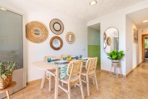 a dining room with a table and chairs and mirrors at Holytom Puerto Pollensa in Port de Pollensa