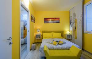 a yellow bedroom with a bed and a bathroom at Chalet al mare in Mondolfo +17 photos