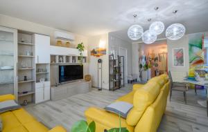 a living room with a yellow couch and a television at Chalet al mare in Mondolfo