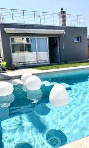 a swimming pool with white spheres in the water at Chalet al mare in Mondolfo