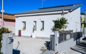 a white house with potted plants on a fence at Chalet al mare in Mondolfo