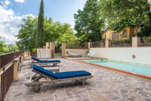 a swimming pool with chaise lounges next to a house at Villa L'incompiuta in Gattaia