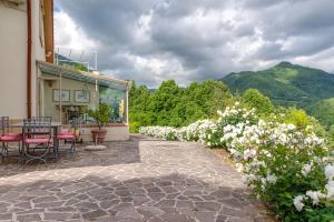 a patio with a table and chairs and flowers at Villa L'incompiuta in Gattaia