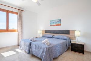 a bedroom with a blue bed with towels on it at Apartamentos Karin 2ºe in Cala d´Or +17 photos