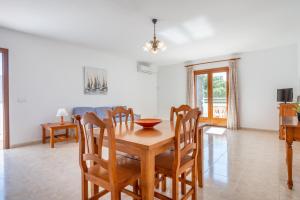 a dining room and kitchen with a wooden table and chairs at Apartamentos Karin 2ºe in Cala d´Or