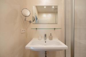 a bathroom with a sink and a mirror and a shower at Alte Stadtvilla am Weinberg 4 in Traben-Trarbach