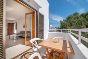 a patio with a wooden table and chairs on a balcony at Apartamentos Karin 2ºe in Cala d´Or
