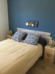 a bedroom with a bed with a blue wall at Gîte Le clos du bannet in Givonne