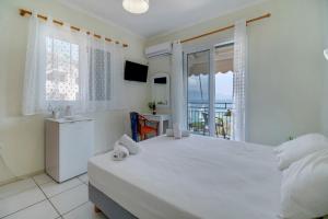 a bedroom with a large white bed and a balcony at S9 room in Nikiana