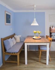 a dining room table with a bench and a couch at kleines Landhaus Bodensee in Überlingen