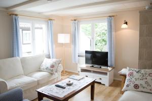 a living room with a white couch and a tv at kleines Landhaus Bodensee in Überlingen