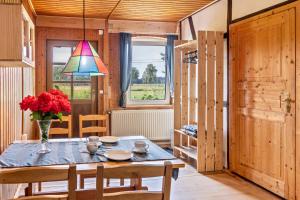 a dining room with a table and a vase of flowers at Elbtalquartier im Grünen in Bleckede