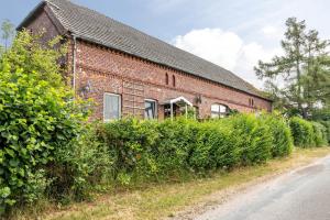 a brick building with bushes next to a street at Elbtalquartier im Grünen in Bleckede