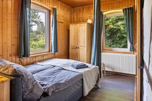 a bedroom with a bed and two windows at Elbtalquartier im Grünen in Bleckede