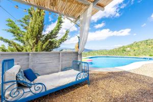 a blue bed sitting next to a swimming pool at Finca Las Nuevas Casa Sofia in Alora