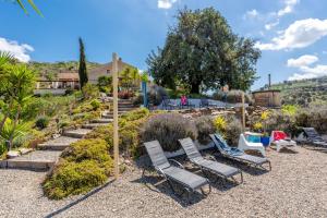 a group of lawn chairs sitting in a garden at Finca Las Nuevas Casa Sofia in Alora