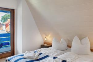 a bedroom with a bed with white pillows and a window at Haus Lotte in Wittmund
