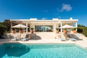 a villa with a swimming pool in front of a house at Villa Mariposa in Sant Lluis
