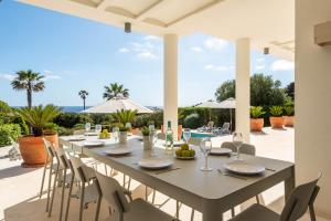 a long table on the patio of a villa at Villa Mariposa in Sant Lluis
