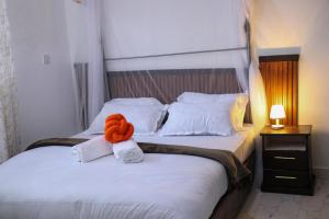 ein Schlafzimmer mit einem Bett, auf dem ein orangefarbenes Handtuch liegt in der Unterkunft Els BnB in Bungoma