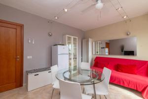 a living room with a glass table and a red couch at A 101 Puntavilla Mare in La Maddalena