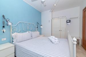 a bedroom with a white bed with blue walls at A 101 Puntavilla Mare in La Maddalena