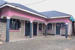 ein rosafarbenes Gebäude mit Säulen davor in der Unterkunft Els BnB in Bungoma